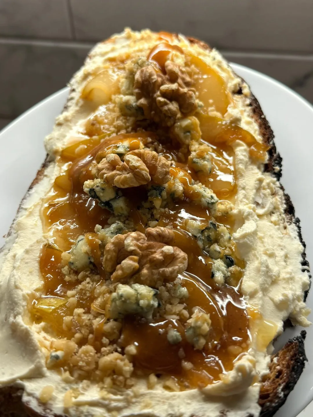 Tostada de masa madre con queso crema, queso azul, nueces y miel, uno de los platos de Amelí